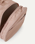 A nude colored pet carrier with an outside pocket for storing essentials and a zipper opening on both ends along with a handle on the top and two attachments for a shoulder strap option. There is a mesh opening on the side of the carrier that can also be covered with a folded flap.