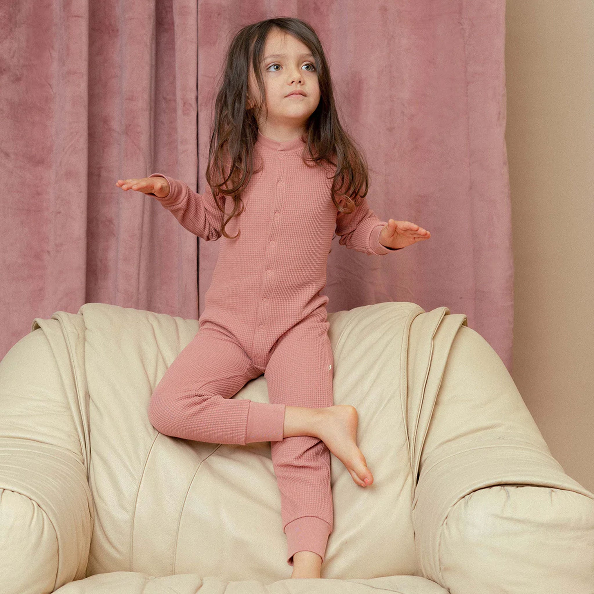 A dusty rose onesie pajamas set featuring a waffle knit material.